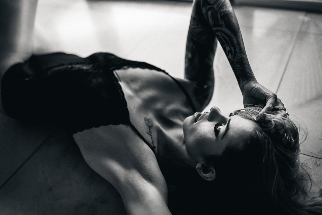 sensualne zdjęcie kobiety leżącej na podłodze tatuaże