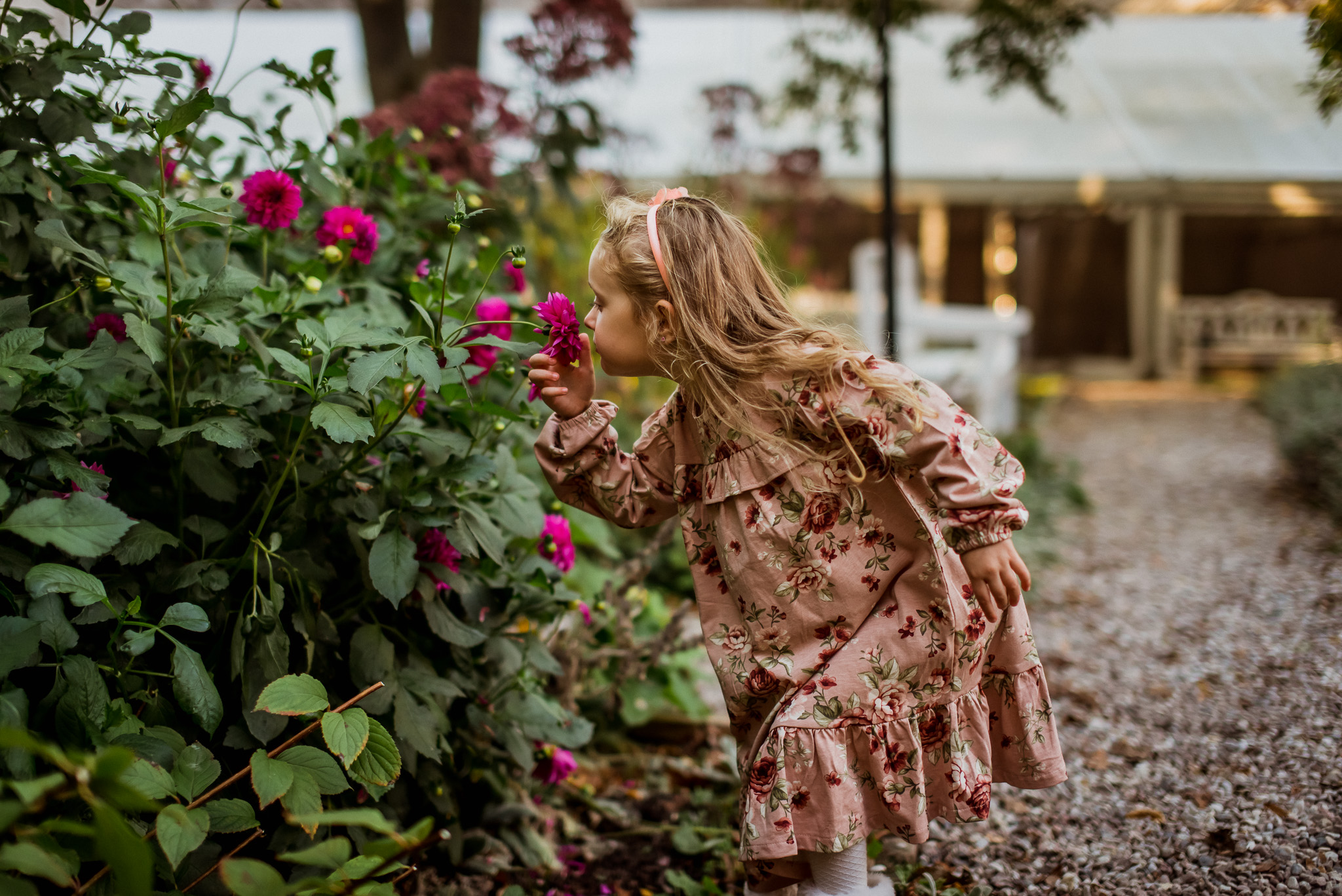dziewczynka w sukience w kwiaty wącha kwiatki
