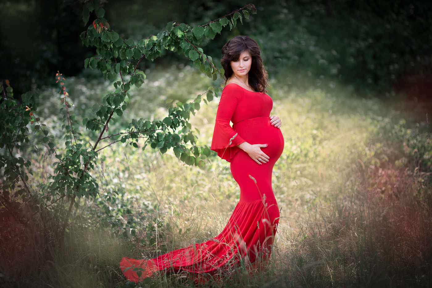 sesja ciążowa w lesie wśród drzew czerwona sukienka 