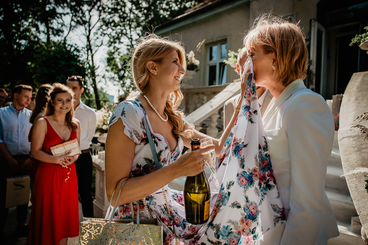 świadkowa ociera łzy pannie młodej ślub w Gdańsku w ogrodzie