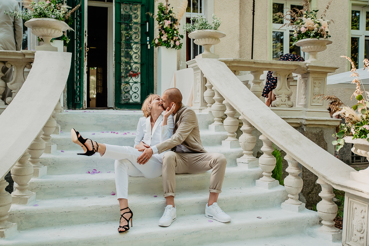 panna młoda w białym garniturze ślub w plenerze