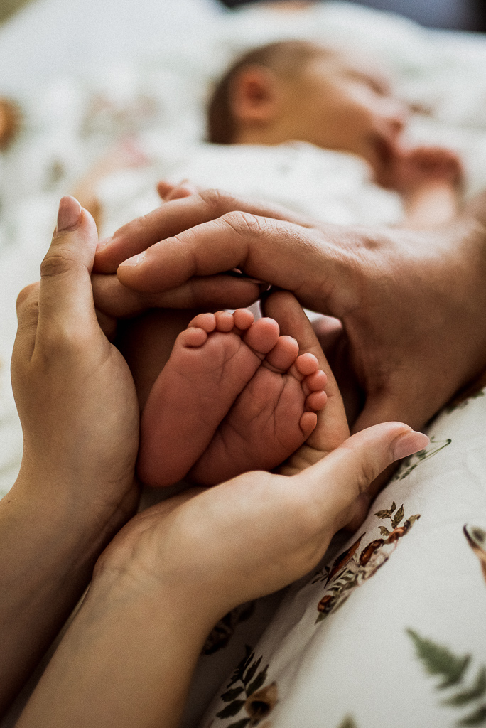 stópki noworodka mieszczą się w dłoni rodziców
