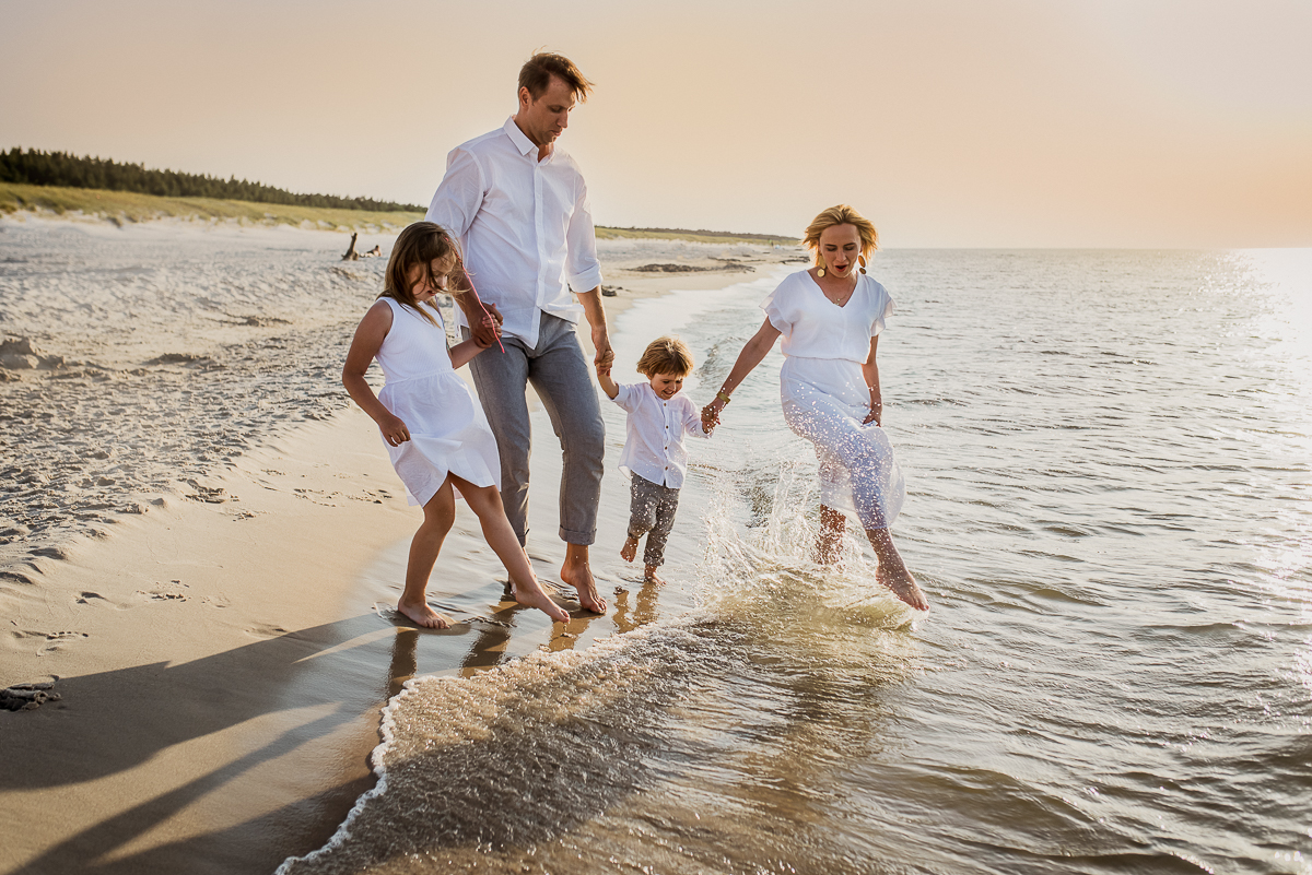rodzina z dziećmi bawi się w wodzie w morzu Bałtyckim