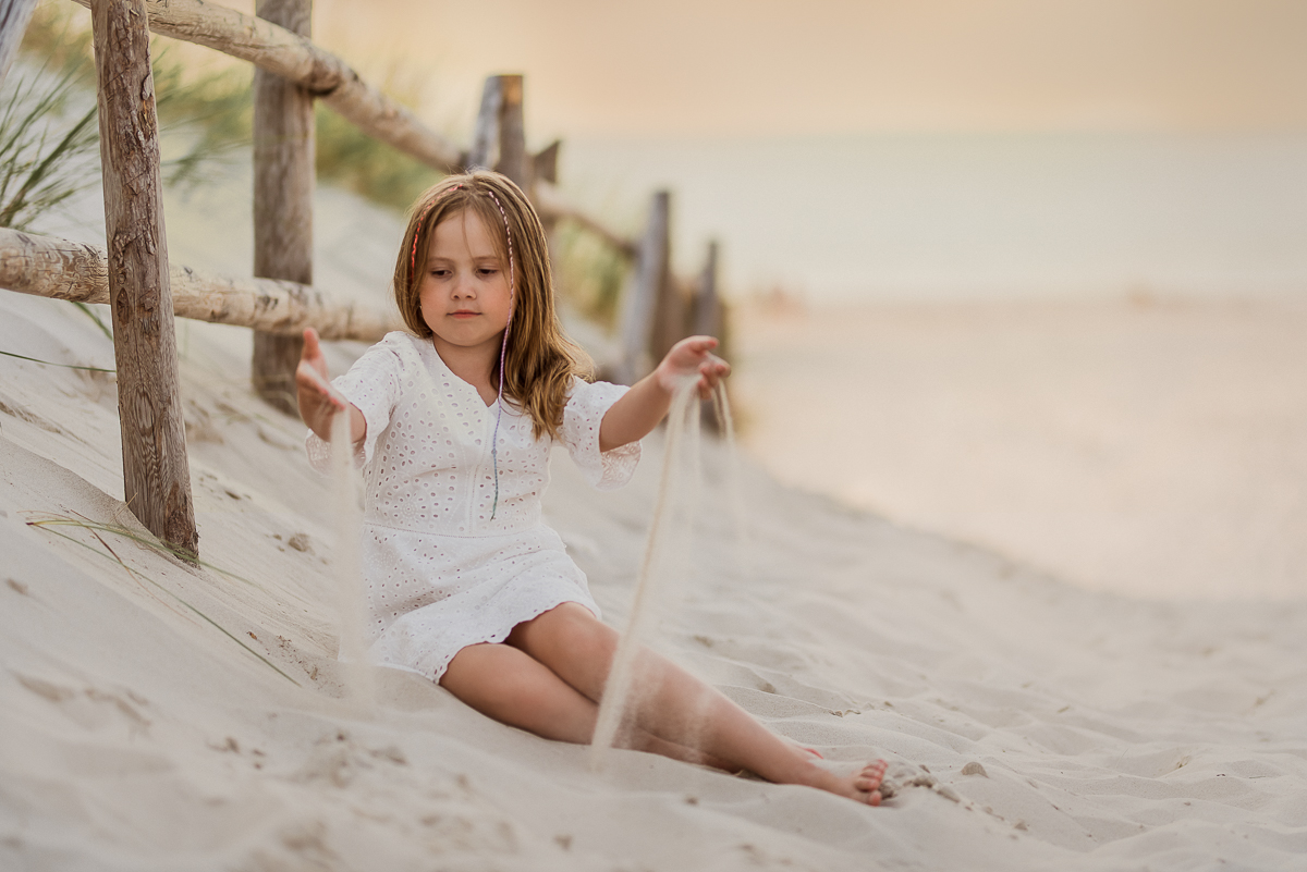 dziewczynka bawi się piaskiem na plaży