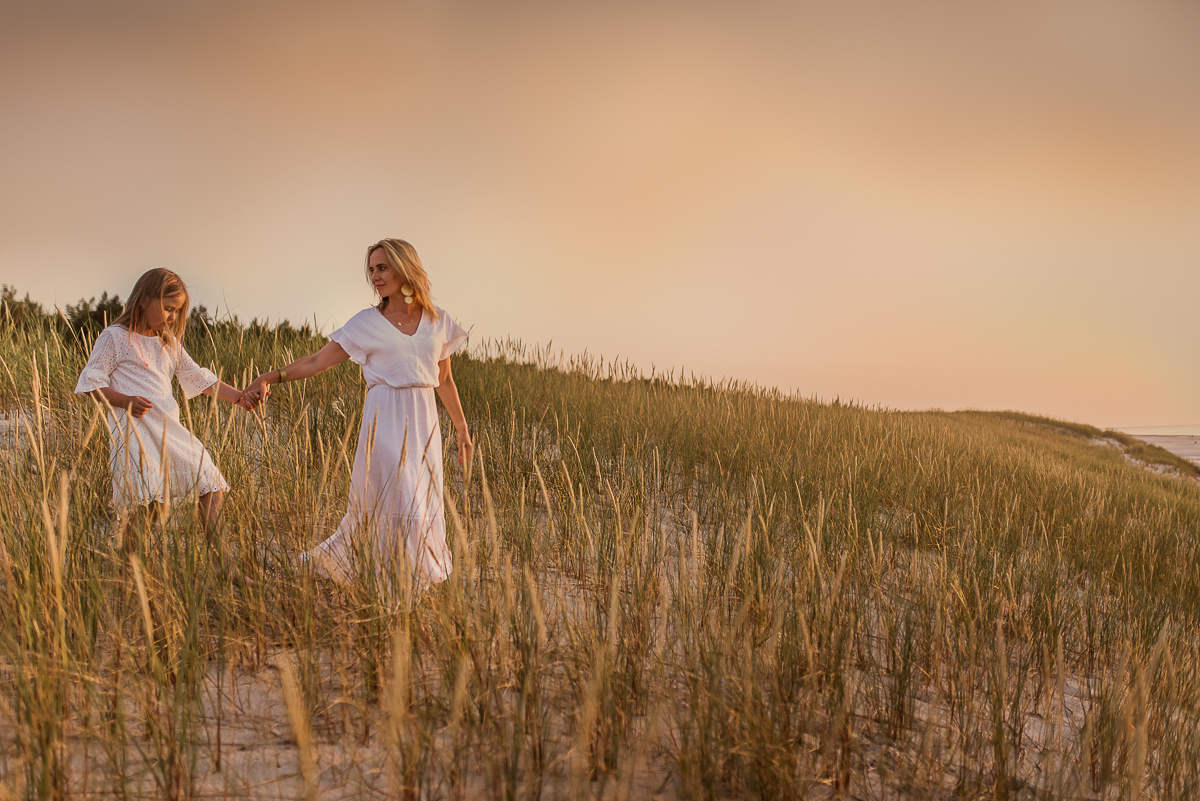 mama i córka ubrane na biało nad morzem na wydmach